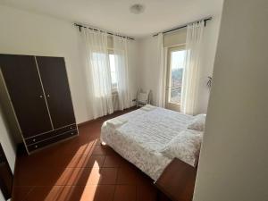 ein Schlafzimmer mit einem Bett und einem großen Fenster in der Unterkunft Ca' Dei Cedri in Marciaga in Costermano sul Garda
