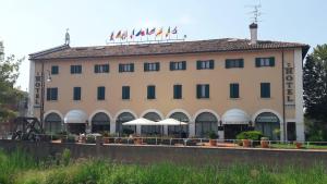 un grand bâtiment avec drapeaux au-dessus dans l'établissement Hotel Bentivoglio Residenza D'Epoca, à Bentivoglio