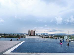 - une piscine au-dessus d'un bâtiment avec des personnes dans l'eau dans l'établissement Kozi ONE Homestay Infinity pool & Gym 2Rooms, à Kuching