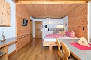 - une cuisine avec 2 lits dans une chambre dotée de murs en bois dans l'établissement Wannig, à Biberwier