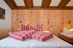 - 2 oreillers sur un lit dans une chambre dotée de murs en bois dans l'établissement Wannig, à Biberwier