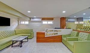 a waiting room with green couches and a sign at Treebo Trend Usha Vasivi Alipiri Road 2 Km From Tirupati Central Bus Station in Tirupati