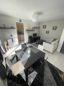 sala de estar con mesa negra y sillas en Les Jonchères en Luxeuil-les-Bains