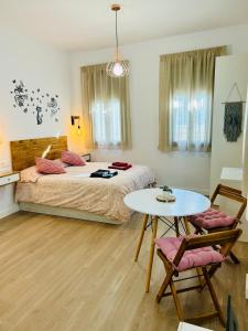 een slaapkamer met een bed en een tafel en stoelen bij Coqueto apartamento céntrico con piscina in Córdoba