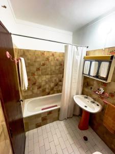 a bathroom with a tub and a sink and a shower at Cantinho dos avós in Fuzeta