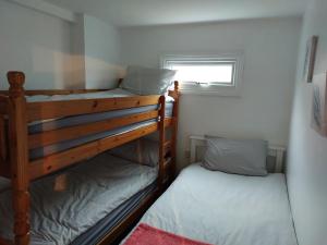 2 łóżka piętrowe w niewielkim pokoju z oknem w obiekcie Sandhaven Beach Chalets w mieście South Shields
