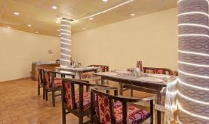 a dining room with tables and chairs and a column at Treebo Trend Kosmos Anamika 1 Km From Nainital Lake in Nainital