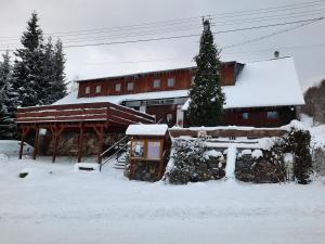 小莫拉夫卡的住宿－Chata Resort Na Horské，前面的地面上积雪的建筑
