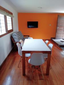 a dining room with a table and chairs and a couch at casita moderna frente al bosque in Mar del Plata