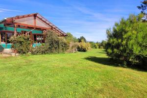 a house with a green yard in front of it at El Viloche - Casa de campo con tinaja in Puerto Montt