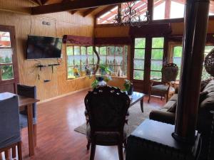 a living room with a couch and a table at El Viloche - Casa de campo con tinaja in Puerto Montt