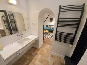 ein Badezimmer mit einer Badewanne, einem Waschbecken und einem Spiegel in der Unterkunft Farinelli at Opera in Budapest