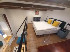 ein kleines Schlafzimmer mit einem Bett mit gelben Kissen in der Unterkunft Farinelli at Opera in Budapest