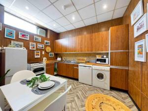 a kitchen with wooden cabinets and a table and a kitchen with a refrigerator at Spacious apartment with Sea Views on Great Yarmouth Seafront in Great Yarmouth