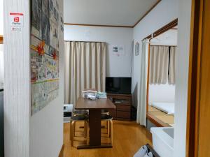 Habitación pequeña con mesa y cama en Guest House Momiji Nikko - Vacation STAY 13409 en Nikko