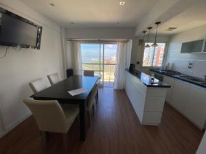 cocina y comedor con mesa y sillas en Una belleza frente al mar en Mar del Plata