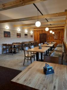 Chata Resort Na Horské في مالا مورافكا: غرفة طعام مع طاولات وكراسي خشبية