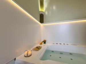 a bathroom with a tub with a mirror and candles at Toscano Palace Luxury Rooms Catania in Catania