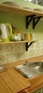 a kitchen counter with a sink and a shelf at Casa Bosio in Bosio