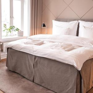a large bed with white sheets and pillows at The Duxiana Malmö in Malmö