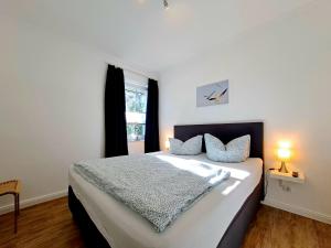 a bedroom with a large white bed with a window at Zur Alten Post Prora in Binz