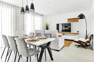 une salle à manger avec une table et des chaises blanches dans l'établissement Apartment Tropical Beach, à San Javier