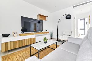 - un salon avec un canapé blanc et une télévision dans l'établissement Apartment Tropical Beach, à San Javier