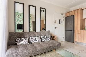 ein Wohnzimmer mit einem Sofa und einigen Spiegeln in der Unterkunft Greatest Vacation by the Blyde in Pretoria