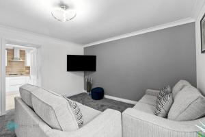 a living room with two couches and a flat screen tv at 3 Bed- The Barracks in Plymouth