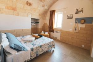 a bedroom with a bed in a room with a brick wall at Villa Susca - villa sul mare in Monopoli