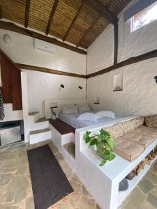 a bedroom with a bed and a couch in a room at Villaggio Serra da Cantareira in Mairiporã