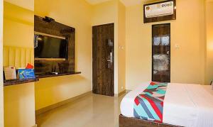 a bedroom with a bed and a flat screen tv at Hotel Palliate Ellisbridge in Ahmedabad