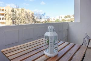 eine Wasserflasche auf einem Holztisch auf einem Balkon in der Unterkunft Apart PRAIA DA ROCHA - AC - WIFi - BY BEDZY in Portimão