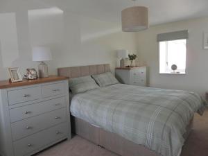 sypialnia z łóżkiem z komodą i oknem w obiekcie Seaside Cottage 2 Bedroom - Bron-Y-Wendon Holiday Park w mieście Llanddulas