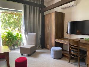 a room with a desk with a television and a chair at Lotus Beach House in Phan Thiet