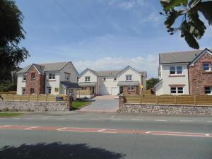 a row of houses with a fence on a street at Anchor Gardens Villa in Lindal in Furness