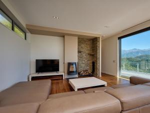 a living room with a couch and a large window at Ata Rangi Lodge - Kaikoura Holiday Home in Kaikoura