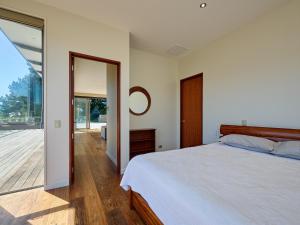 a bedroom with a bed and a sliding glass door at Ata Rangi Lodge - Kaikoura Holiday Home in Kaikoura
