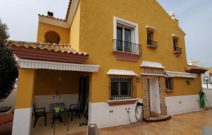 een geel huis met een tafel ervoor bij Villa Tahona in Zahara de los Atunes