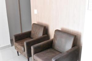 two chairs in a room next to a wall at Rai Hotel - By UP Hotel - próximo a Prefeitura in Cascavel