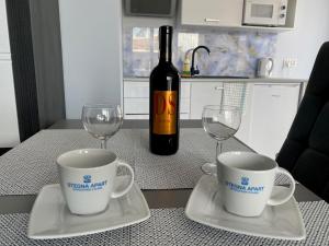 a bottle of wine and two wine glasses on a table at Stegna Apart in Stegna