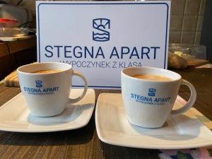duas chávenas de café sentadas em pratos numa mesa em Stegna Apart em Stegna