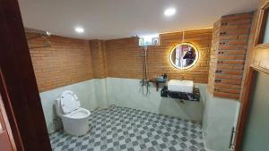 a bathroom with a toilet and a sink and a mirror at Floor river view in Cat Tien