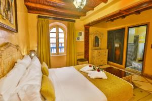 a bedroom with a large bed with towels on it at Riad Mimouna in Essaouira