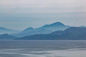 a large body of water with mountains in the background at The Anchor House in Symi
