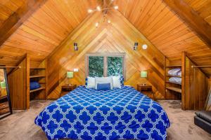 a bedroom with a blue bed in a wooden room at Kelly's Chalet in Girdwood