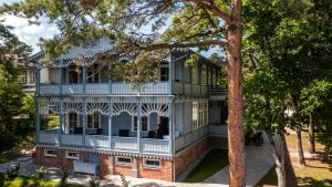 una imagen de una casa con un porche envolvente en Villa Loebel - Exceptional Queen Louisa two bedroom apartment with 2 balconies, en Juodkrantė