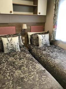 two beds sitting next to each other in a bedroom at 41 Lade Links St Andrews Holiday Park in St Andrews