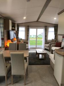 a living room with a couch and a table and chairs at 41 Lade Links St Andrews Holiday Park in St. Andrews