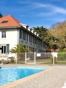 een huis met een hek en een zwembad bij Les Pastourelles in Capbreton